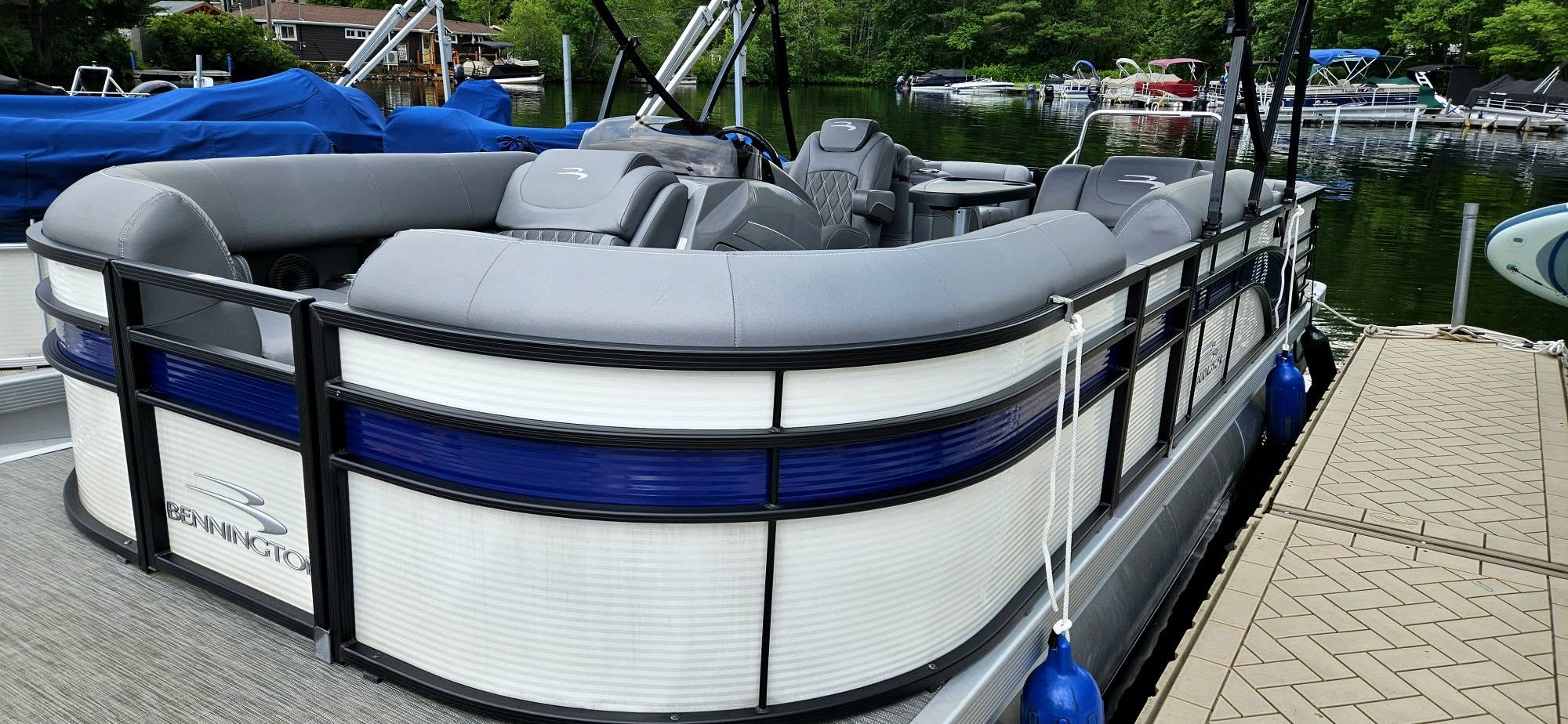 Bennington pontoon with blue-trim hull detailed at the dock